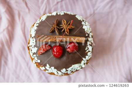 Delicious Easter cake topped with chocolate glaze, cherries, star anise, and cinnamon. Festive dessert perfect for spring celebrations 124619263