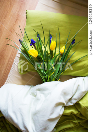 a bouquet of beautiful yellow tulips and irises lie on the bed-morning, surprise a bouquet of beautiful yellow tulips and irises lie on the bed-morning, surprise 124619359