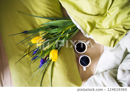 two cups of coffee and a bouquet of beautiful flowers lie in bed-happy morning 124619360