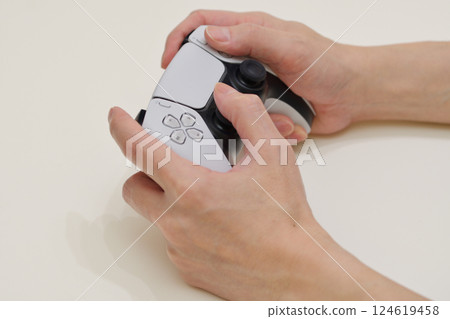 Hands operating a game with a controller 124619458