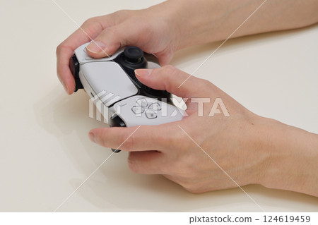 Hands operating a game with a controller 124619459