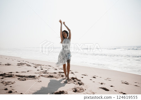 Joyful Woman Dancing Barefoot on Beach Joyful Woman Dancing Barefoot on Beach 124619555