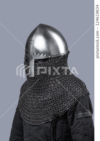 Simple Norman Helmet with Nasal Bar and Chainmail. Classic medieval head protection featuring a central nose guard and attached chainmail neck cover. 124619634