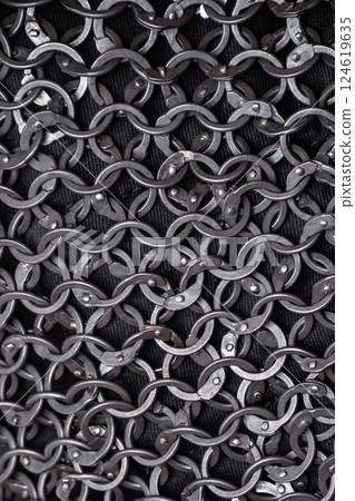 Detailed Close-Up of Interlocked Medieval Chainmail Rings. Intricate texture of metal links forming a strong and flexible defensive fabric. Detailed Close-Up of Interlocked Medieval Chainmail Rings. Intricate texture of metal links forming a strong and flexible defensive fabric. 124619635