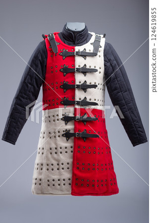 Red and White Brigandine Armor with Studs and Black Straps. This image shows a brigandine armor that is divided vertically into two halves, one red and the other white. It features rows of small 124619855