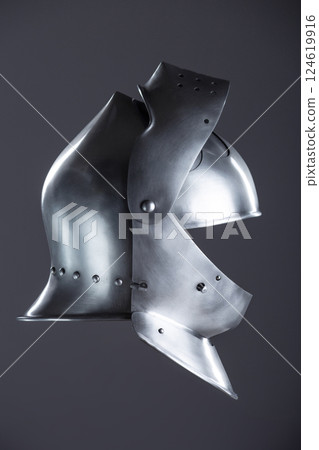 Medieval Knight's Polished Steel Armet Helmet. Detailed close-up of a shiny, historical piece of protective headgear worn by knights in the Middle Ages. Medieval Knight's Polished Steel Armet Helmet. Detailed close-up of a shiny, historical piece of protective headgear worn by knights in the Middle Ages. 124619916