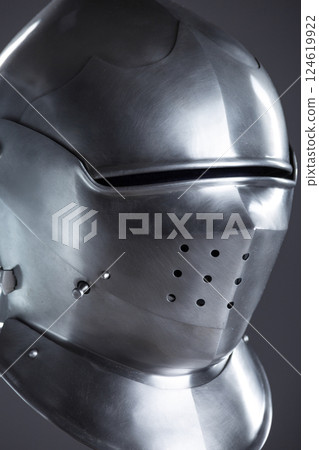 Polished Silver Medieval Armet Helmet with Perforated Visor. This shiny silver armet features a rounded skull, a protective bevor, and a visor with multiple small perforations. 124619922