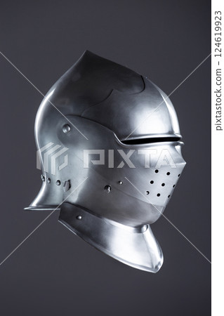 Polished Silver Medieval Armet Helmet with Perforated Visor. This shiny silver armet features a rounded skull, a protective bevor, and a visor with multiple small perforations. 124619923