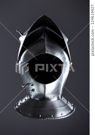 Silver Medieval Helmet with Lifted Visor. A polished silver helmet with a visor slightly raised, revealing a glimpse inside. 124619927