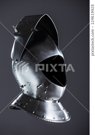 Silver Medieval Helmet with Lifted Visor. A polished silver helmet with a visor slightly raised, revealing a glimpse inside. 124619928