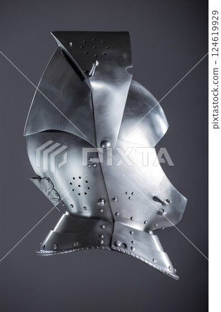 Silver Medieval Helmet with Lifted Visor. A polished silver helmet with a visor slightly raised, revealing a glimpse inside. 124619929