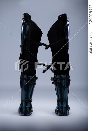 Shiny Steel Medieval Leg Armor. Full leg protection with straps and buckles detail. 124619942
