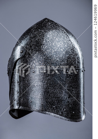 Closed Medieval Knight's Helmet with Small Perforations. This image shows a closed medieval knight's helmet, likely made of steel, with a pointed top and small perforations for ventilation and vision. 124619969