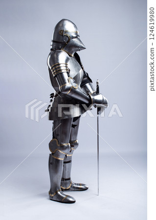 Full Suit of Fourteenth Century Knight's Plate Armor. Impressive display of medieval protective gear, including helmet, breastplate, gauntlets, and greaves Full Suit of Fourteenth Century Knight's Plate Armor. Impressive display of medieval protective gear, including helmet, breastplate, gauntlets, and greaves 124619980