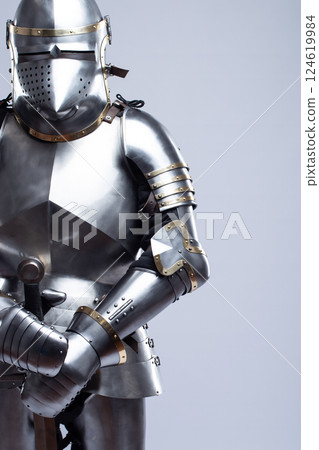 Full Suit of Fourteenth Century Knight's Plate Armor. Impressive display of medieval protective gear, including helmet, breastplate, gauntlets, and greaves 124619984