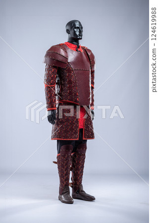 Brown Leather Fantasy Armor Set for LARP Cosplay. Full costume on a mannequin with intricate details and red accents. Brown Leather Fantasy Armor Set for LARP Cosplay. Full costume on a mannequin with intricate details and red accents. 124619988
