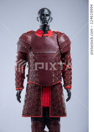 Brown Leather Fantasy Armor Set for LARP Cosplay. Full costume on a mannequin with intricate details and red accents. Brown Leather Fantasy Armor Set for LARP Cosplay. Full costume on a mannequin with intricate details and red accents. 124619994