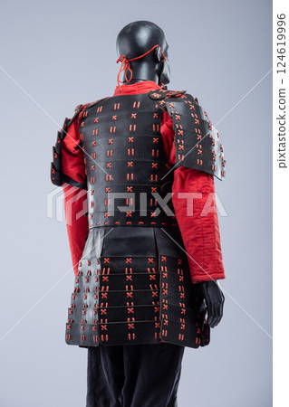 Black and Red Leather Armor Set on Mannequin. Full medieval warrior outfit with detailed stitching and metal accents. Black and Red Leather Armor Set on Mannequin. Full medieval warrior outfit with detailed stitching and metal accents. 124619996