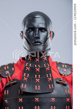 Black and Red Leather Armor Set on Mannequin. Full medieval warrior outfit with detailed stitching and metal accents. Black and Red Leather Armor Set on Mannequin. Full medieval warrior outfit with detailed stitching and metal accents. 124620004
