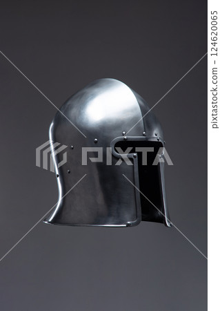 Silver Medieval Helmet with Open Face Guard. This image showcases a shiny silver helmet with an open face, featuring a rounded top and small rivets along the edges. Silver Medieval Helmet with Open Face Guard. This image showcases a shiny silver helmet with an open face, featuring a rounded top and small rivets along the edges. 124620065