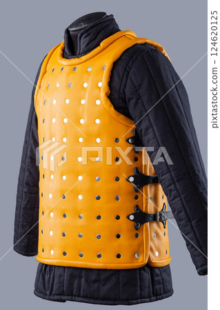 Bright Yellow Brigandine Armor with Studs. This image shows a bright yellow brigandine armor, featuring rows of silver studs and black straps with buckles on the sides. 124620125