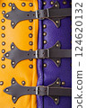 Close-Up of Colorful Brigandine Armor Details. This image provides a detailed close-up of the colorful brigandine armor, showcasing the studs, leather straps with buckles, and the contrasting purple Close-Up of Colorful Brigandine Armor Details. This image provides a detailed close-up of the colorful brigandine armor, showcasing the studs, leather straps with buckles, and the contrasting purple 124620132