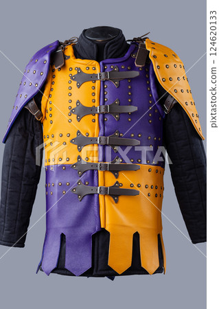 Colorful Brigandine Armor with Studs and Buckles. This image shows a vibrant piece of brigandine armor, featuring a combination of purple and yellow leather sections adorned with studs and secured 124620133