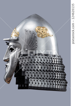 Silver Samurai Helmet with Ornate Gold Details and Fierce Mask. This image showcases a silver samurai helmet with intricate gold decorations on the crown and a detailed face mask with a stern 124620135