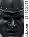 Dark Samurai Helmet with Menacing Face Mask. This image features a dark, almost black, samurai helmet with a detailed face mask displaying a fierce expression. Dark Samurai Helmet with Menacing Face Mask. This image features a dark, almost black, samurai helmet with a detailed face mask displaying a fierce expression. 124620143