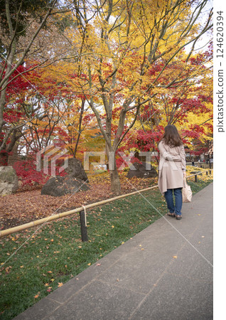 A woman enjoying the autumn leaves of Joshinji Temple 124620394