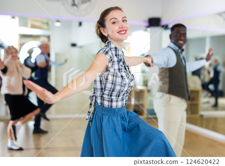 Cheerful female practicing lindy hop in pair with man 124620422