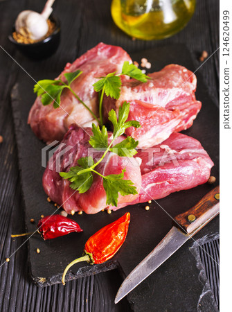 Raw meat with herbs and spices ready for cooking are on wooden table 124620499