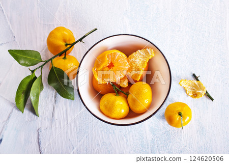 Fresh mandarin oranges fruit or tangerines with leaves on a table Fresh mandarin oranges fruit or tangerines with leaves on a table 124620506