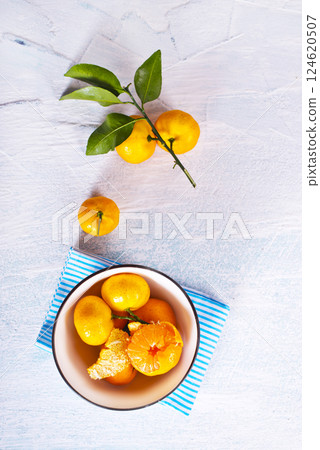 Fresh mandarin oranges fruit or tangerines with leaves on a table Fresh mandarin oranges fruit or tangerines with leaves on a table 124620507