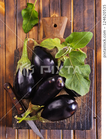 fresh eggplant on wooden cutting board 124620535