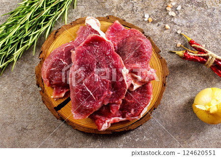Raw meat with herbs and spices ready for cooking are on wooden table 124620551