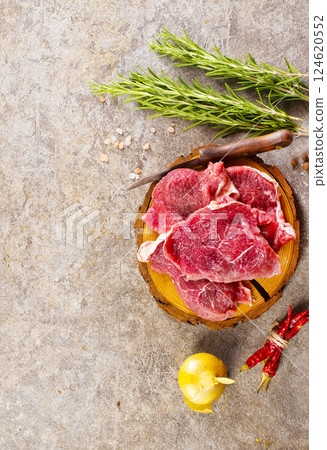 Raw meat with herbs and spices ready for cooking are on wooden table 124620552