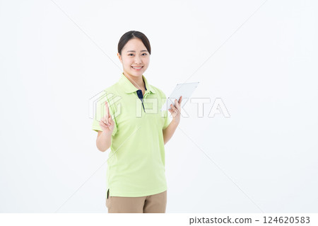 A young woman working as a caregiver using a tablet 124620583