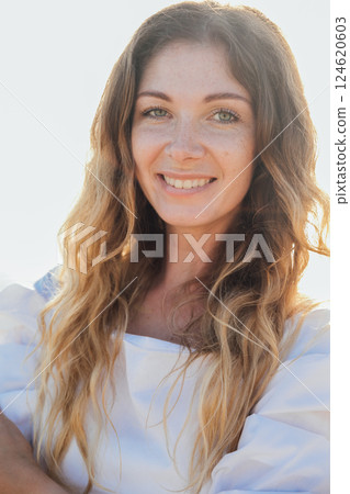 Beautiful slim fashionable woman in white summer dress on the beach by the sea 124620603