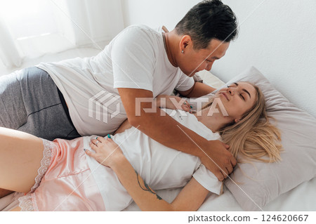 A man and a woman woke up in the morning in the bedroom on the bed A man and a woman woke up in the morning in the bedroom on the bed 124620667