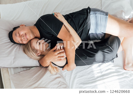 Man and woman sleeping side by side in bedroom on bed Man and woman sleeping side by side in bedroom on bed 124620668