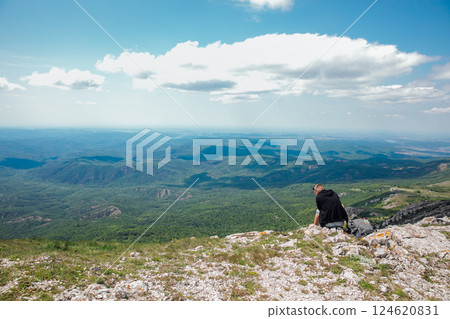 Male traveler looking at the view from the top of the mountain on a hike 124620831