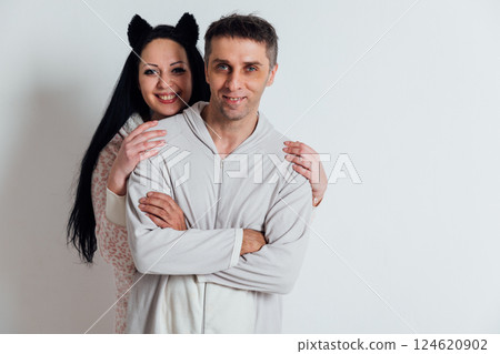 Man and woman in pajamas hugging family in bedroom Man and woman in pajamas hugging family in bedroom 124620902