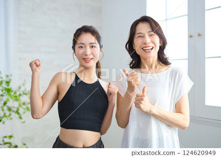 Two women in yoga wear doing fist pumps 124620949