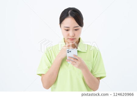 A young woman working as a caregiver using a smartphone 124620966