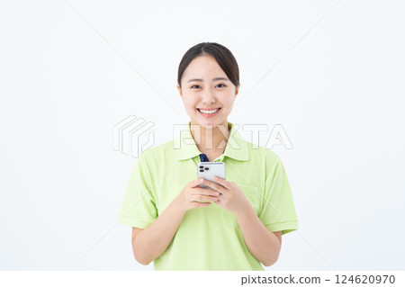 一名擔任護工的年輕女性正在使用智慧型手機 124620970