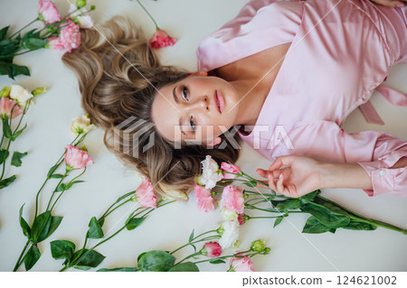 fashionable woman in summer dress lying with flowers 124621002