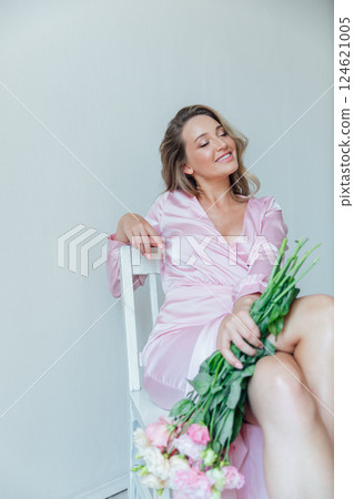 fashionable woman in light pink dress with bouquet of flowers fashionable woman in light pink dress with bouquet of flowers 124621005