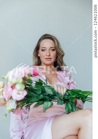 fashionable woman in light pink dress with bouquet of flowers fashionable woman in light pink dress with bouquet of flowers 124621006