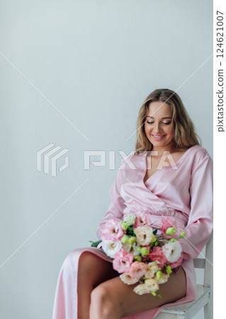 fashionable woman in light pink dress with bouquet of flowers fashionable woman in light pink dress with bouquet of flowers 124621007